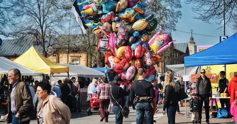 Markkinaväkeä, myyntikojuja ja ilmapalloja.